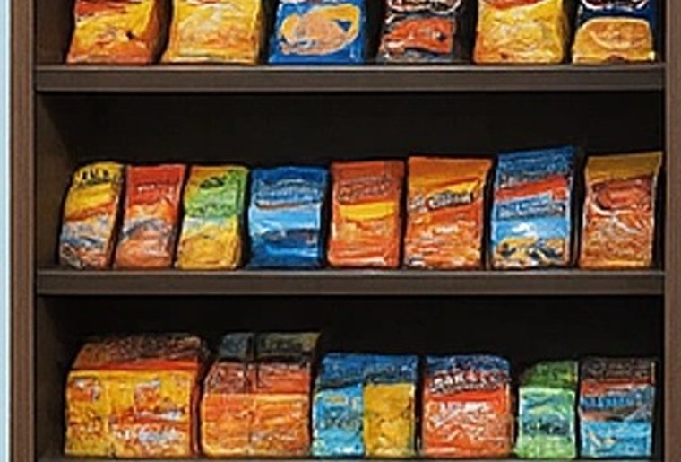 A shelf unit stocked with bags of chips and snacks